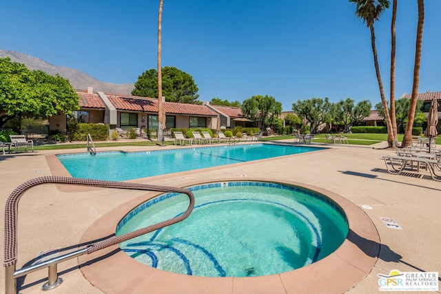 view of swimming pool featuring a mountain view and a patio