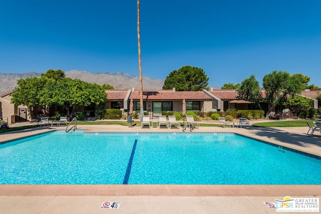 view of swimming pool featuring a mountain view and a patio