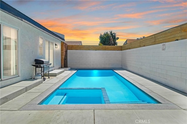 pool at dusk featuring grilling area