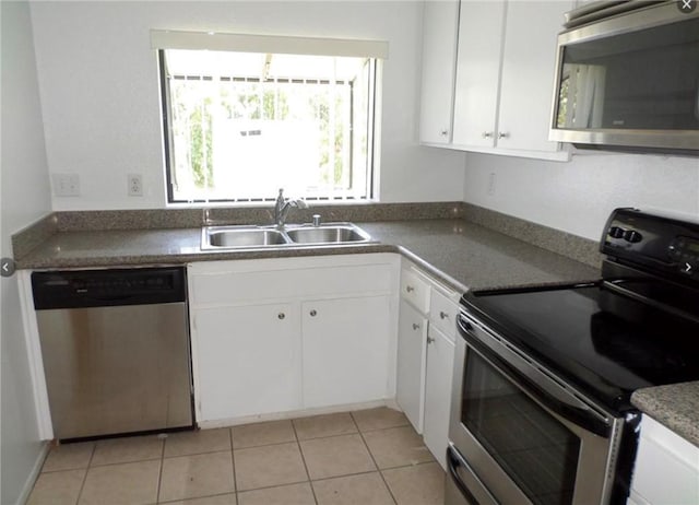 kitchen featuring white cabinetry, sink, light tile patterned floors, and stainless steel appliances