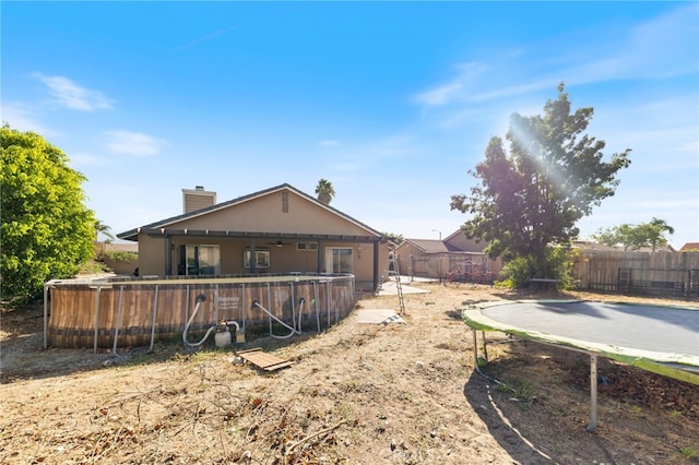 back of house with a fenced in pool