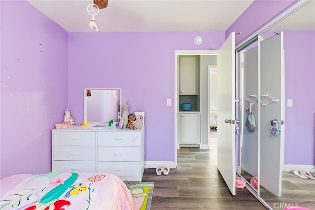 bedroom with dark hardwood / wood-style floors and a closet