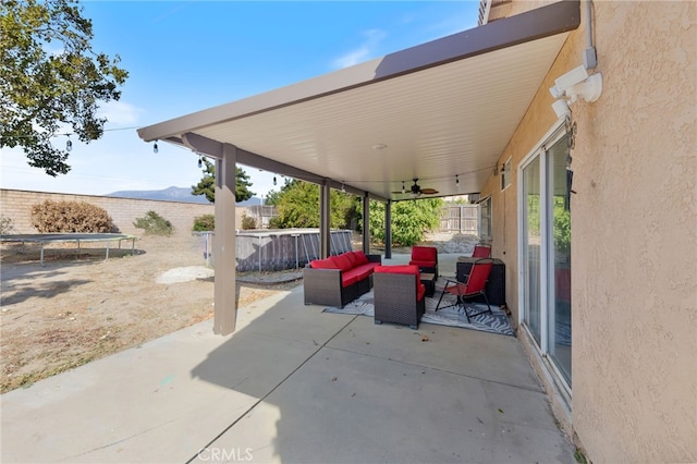 view of patio featuring an outdoor hangout area, a mountain view, and ceiling fan