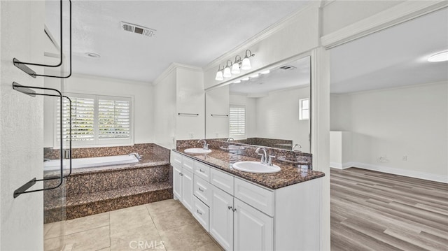 bathroom with a relaxing tiled tub, a textured ceiling, vanity, crown molding, and hardwood / wood-style flooring