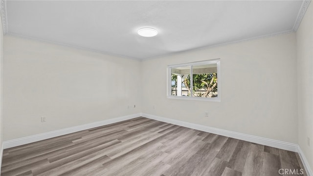 empty room with light hardwood / wood-style floors and ornamental molding