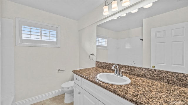 bathroom with vanity, toilet, a healthy amount of sunlight, and a tile shower