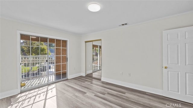 empty room with light hardwood / wood-style floors and ornamental molding