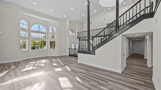 unfurnished living room with a high ceiling and hardwood / wood-style flooring