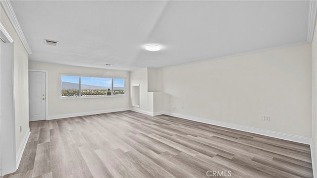 unfurnished room featuring light hardwood / wood-style flooring and crown molding