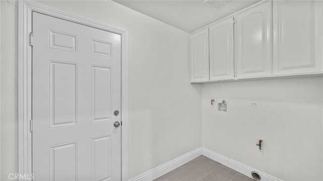 clothes washing area featuring hookup for a washing machine and cabinets