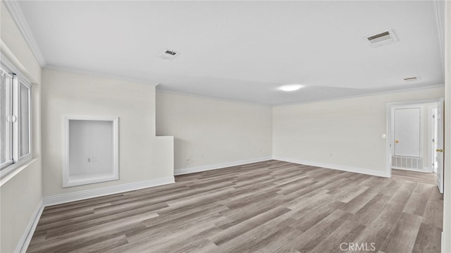 spare room featuring light hardwood / wood-style floors and crown molding