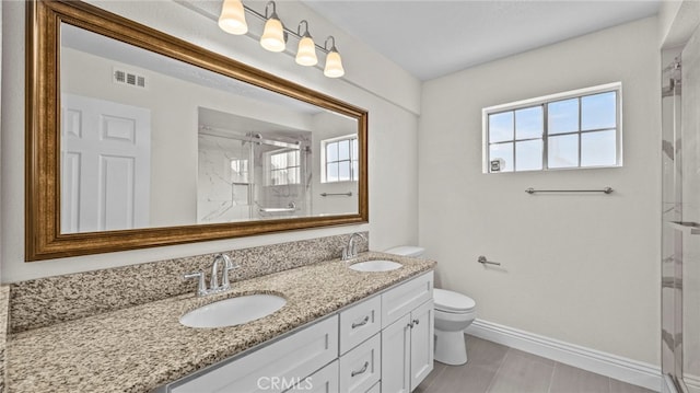 bathroom with a wealth of natural light, vanity, a shower with shower door, and toilet