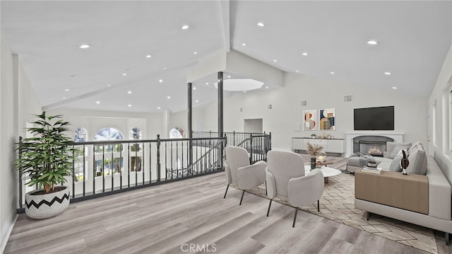 living room with high vaulted ceiling and light hardwood / wood-style floors