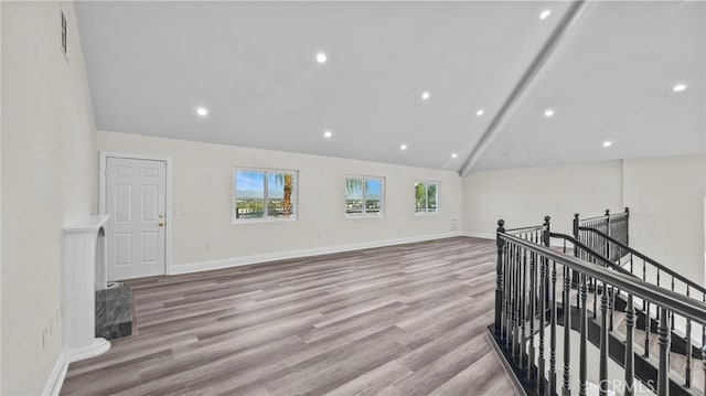 interior space featuring lofted ceiling with beams and light hardwood / wood-style flooring