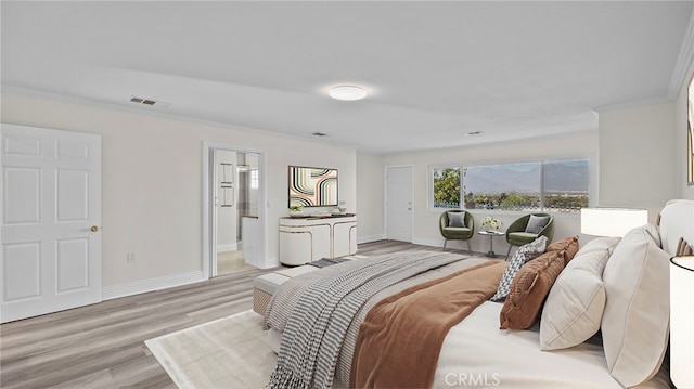 bedroom featuring connected bathroom, light hardwood / wood-style floors, and ornamental molding