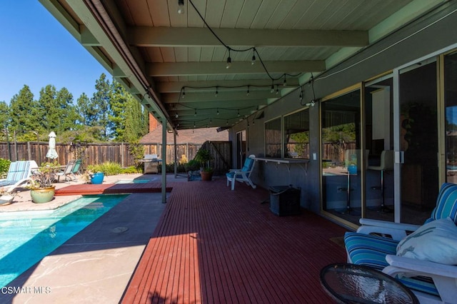 wooden terrace featuring a fenced in pool, area for grilling, and a patio area