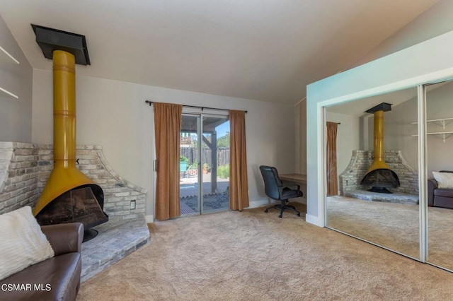 interior space featuring a wood stove, carpet floors, and lofted ceiling