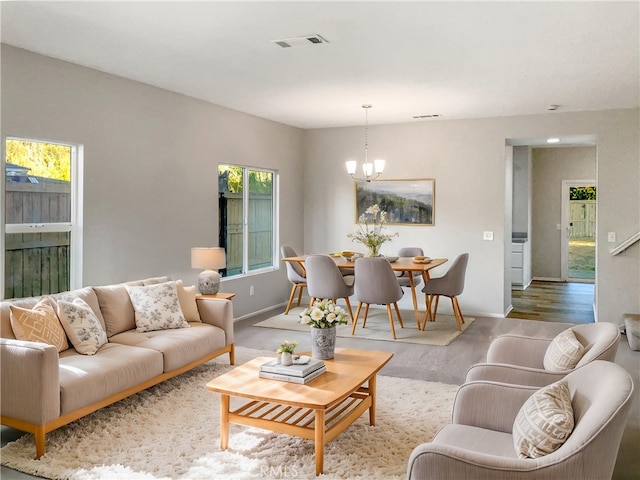 living room featuring light hardwood / wood-style floors, an inviting chandelier, and plenty of natural light