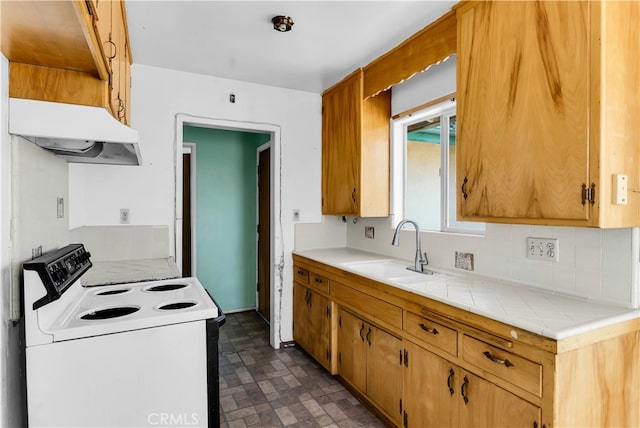 kitchen with sink, electric range, tile counters, and backsplash