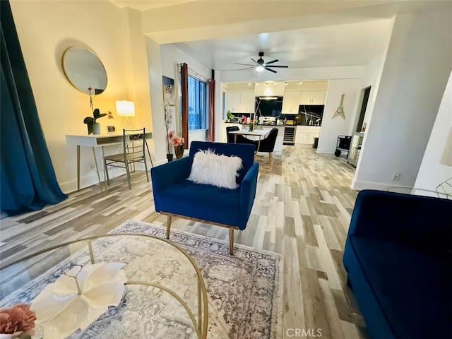 living room featuring ceiling fan and light hardwood / wood-style floors