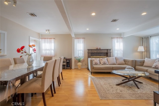 living room featuring beam ceiling and light hardwood / wood-style flooring