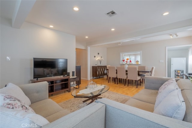 living room featuring light hardwood / wood-style floors and beam ceiling