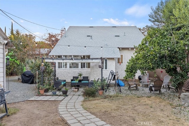 back of property with a fire pit and a patio area