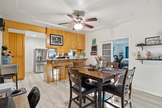 dining room featuring ceiling fan, light wood-type flooring, and french doors