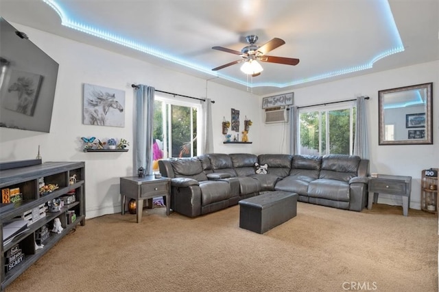 carpeted living room with a wall mounted AC, a healthy amount of sunlight, and ceiling fan