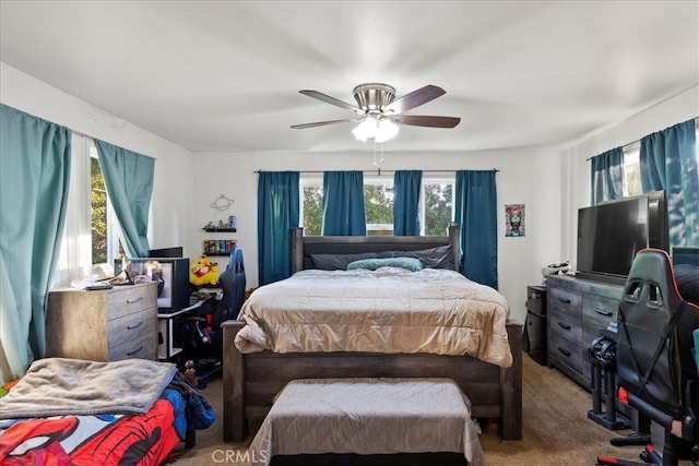 carpeted bedroom featuring multiple windows and ceiling fan