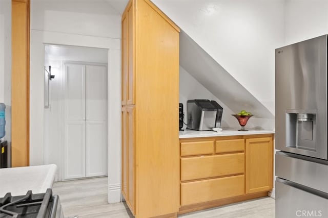 kitchen featuring light wood-type flooring, light brown cabinetry, and stainless steel fridge