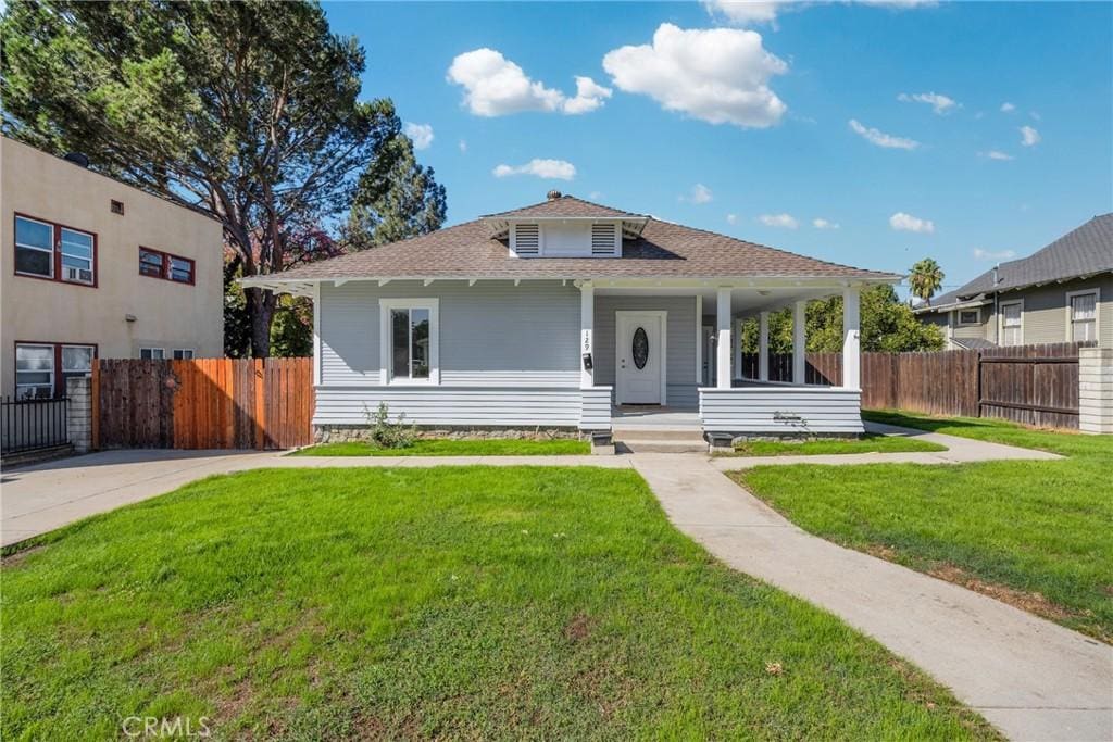 view of front of house with covered porch and a front lawn