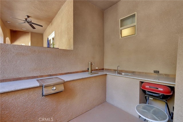 view of patio with ceiling fan and sink