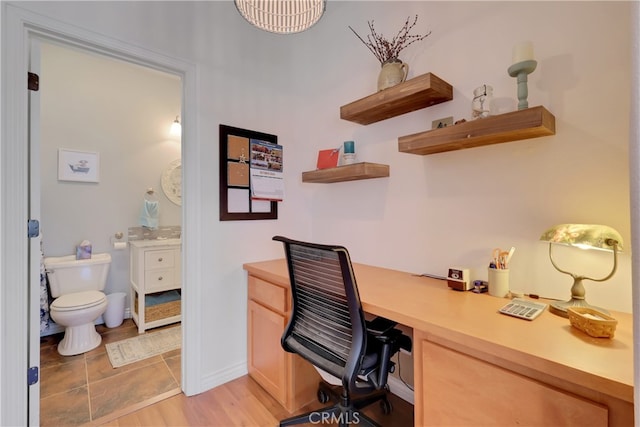 office with light hardwood / wood-style floors and built in desk