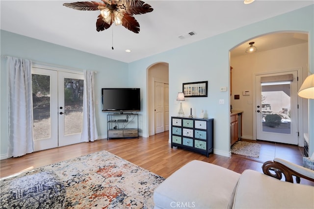 living room featuring french doors, ceiling fan, and wood-type flooring