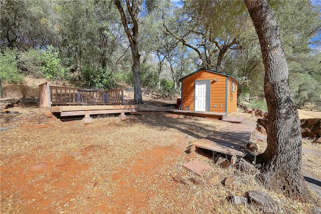 view of yard featuring a wooden deck and a shed