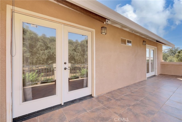 doorway to outside with tile patterned floors and french doors