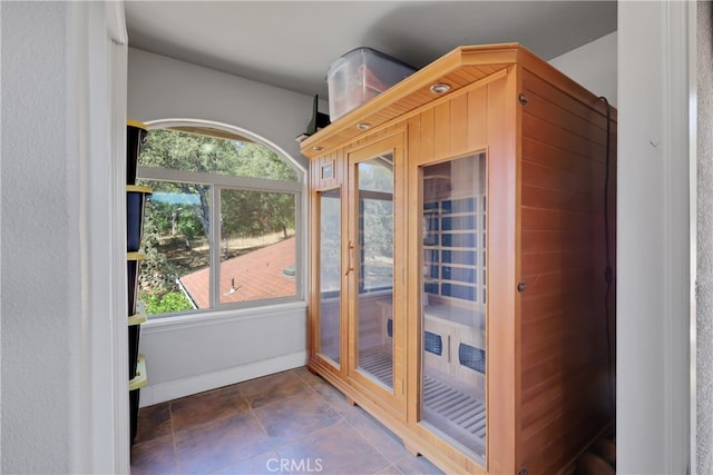 doorway with dark tile patterned floors and a wealth of natural light