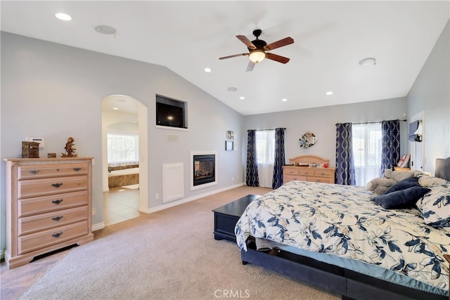 carpeted bedroom featuring ceiling fan, lofted ceiling, and ensuite bathroom