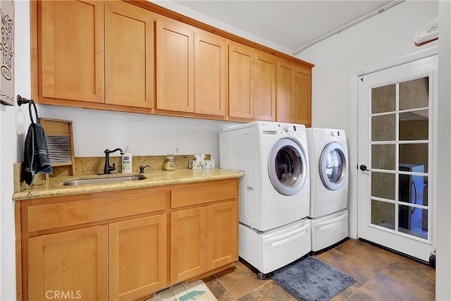 laundry area featuring sink, washing machine and dryer, and cabinets