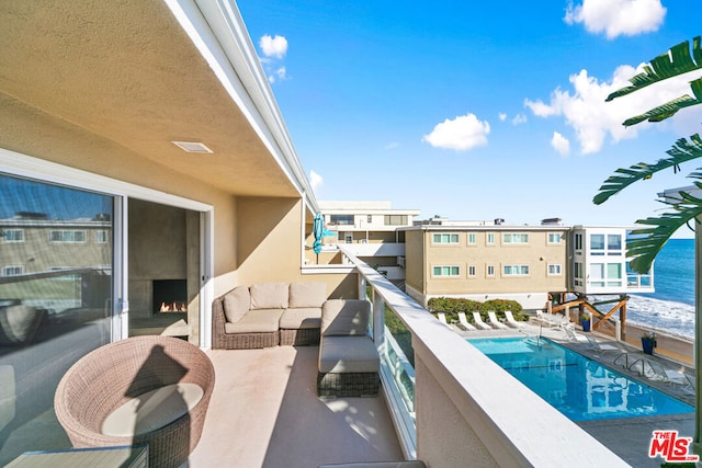 balcony featuring an outdoor living space and a water view