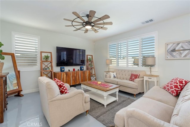 living room featuring ceiling fan and concrete flooring