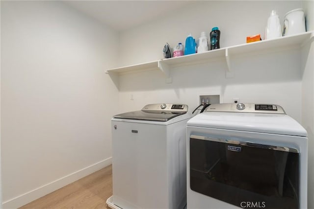 washroom featuring washer and dryer and light hardwood / wood-style flooring