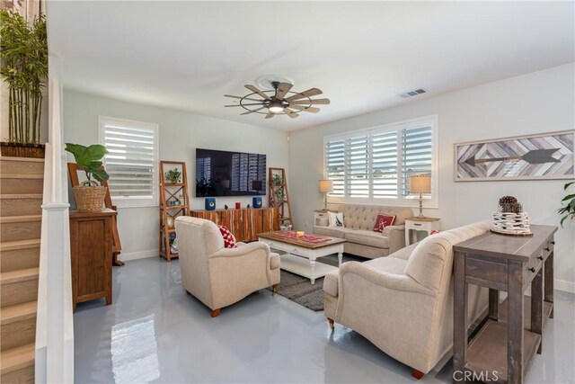 living room with ceiling fan and concrete flooring