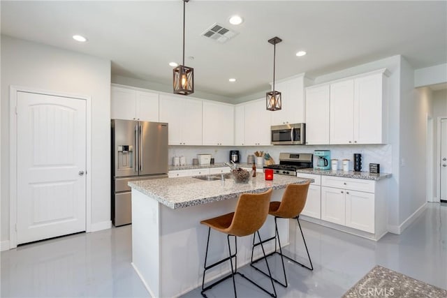 kitchen with an island with sink, white cabinets, sink, and stainless steel appliances