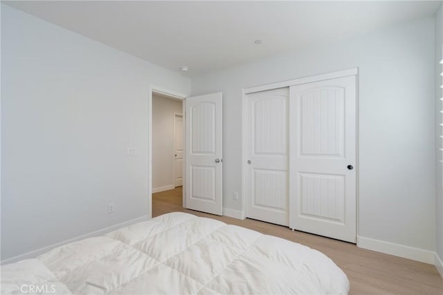 bedroom with a closet and light hardwood / wood-style floors