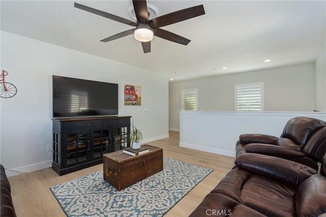 living room with ceiling fan and light hardwood / wood-style flooring