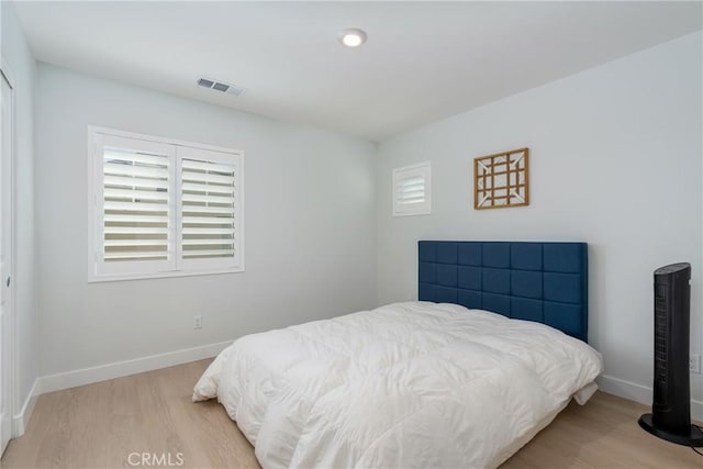 bedroom featuring multiple windows and light hardwood / wood-style floors