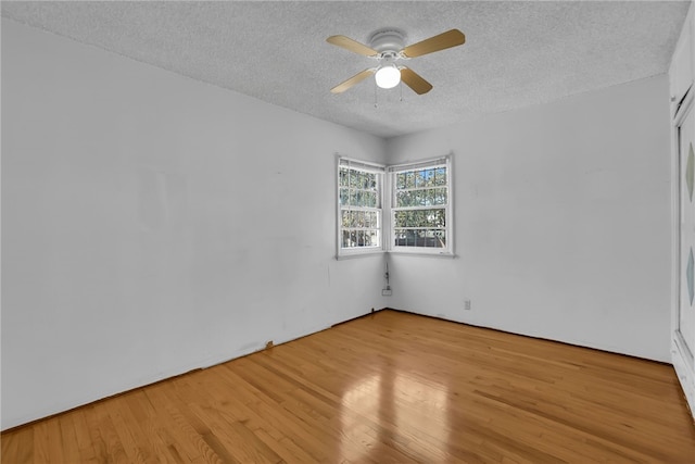 empty room featuring a textured ceiling, light hardwood / wood-style floors, and ceiling fan