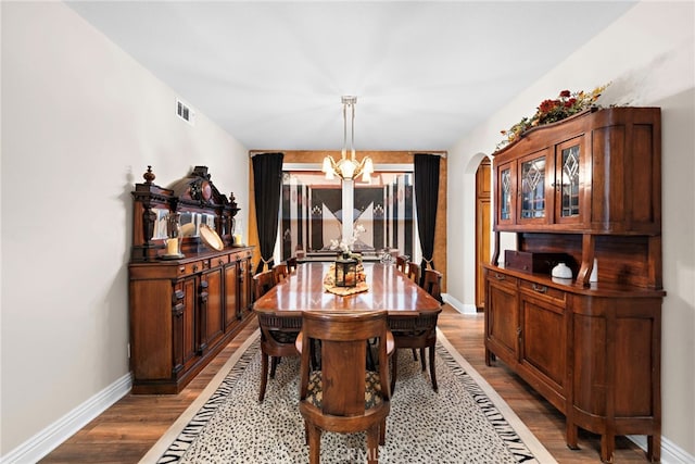 dining room with hardwood / wood-style floors and a chandelier